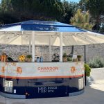 Mobilni bar pod suncobranom uz kameni zid